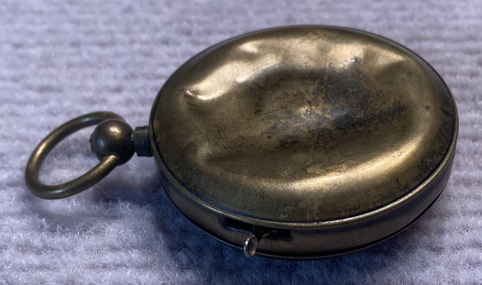 Side view of reverse of mechanical dice game encased in a pocket watch housing