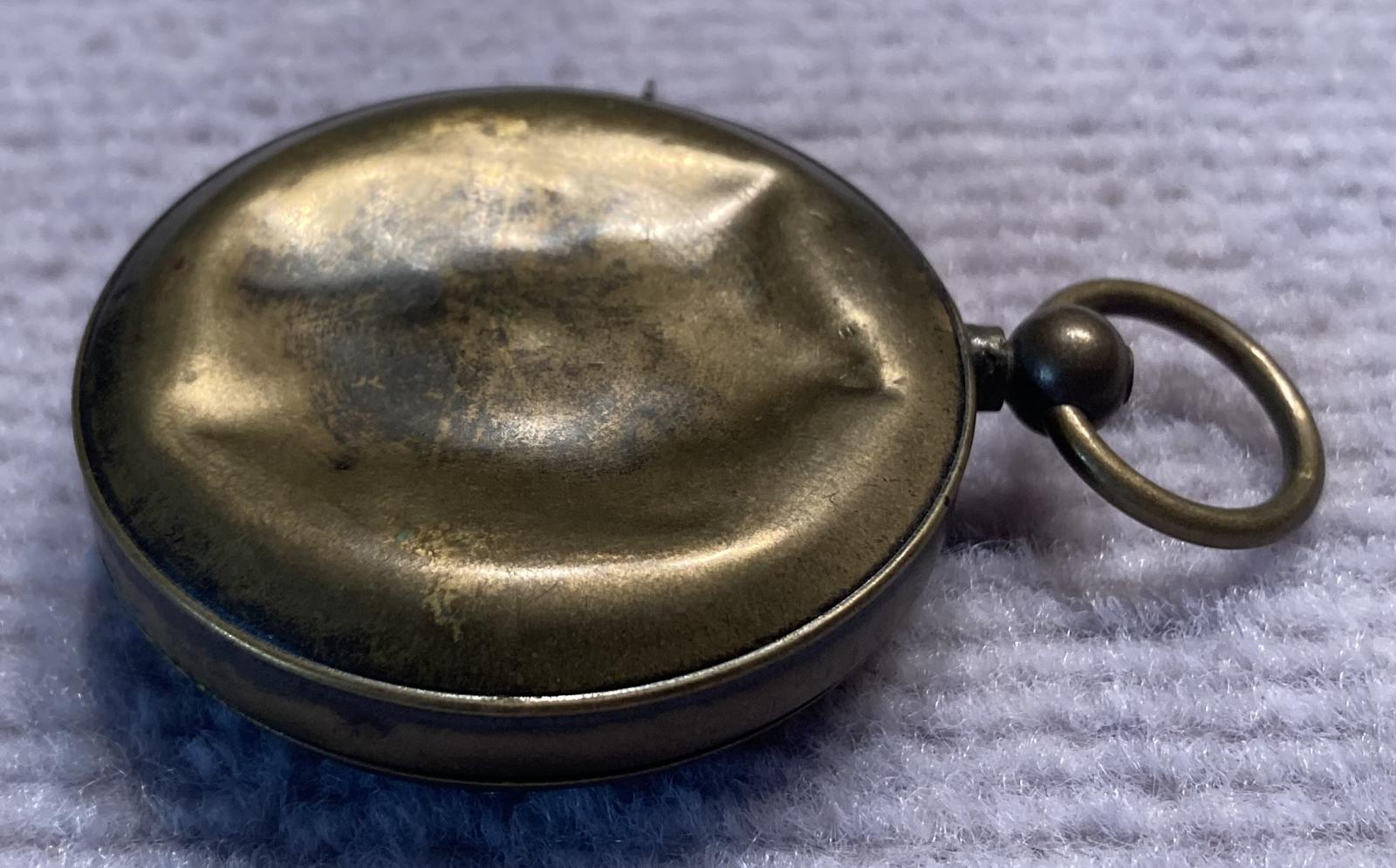 Other side view of reverse of mechanical dice game encased in a pocket watch housing