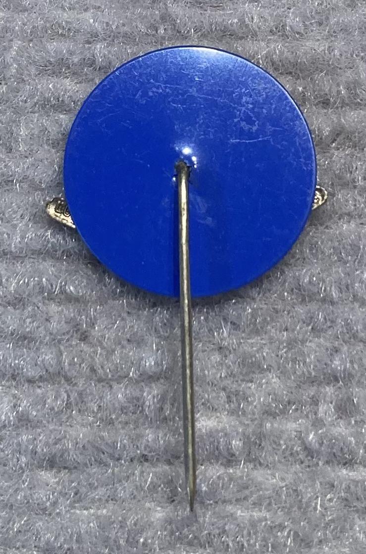 Reverse of miniature Rising Sun badge and boomerang stick pin on blue backing