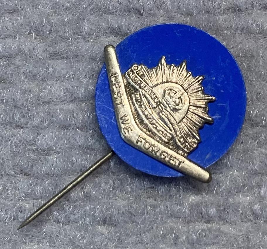 Other angled view of miniature Rising Sun badge and boomerang stick pin on blue backing