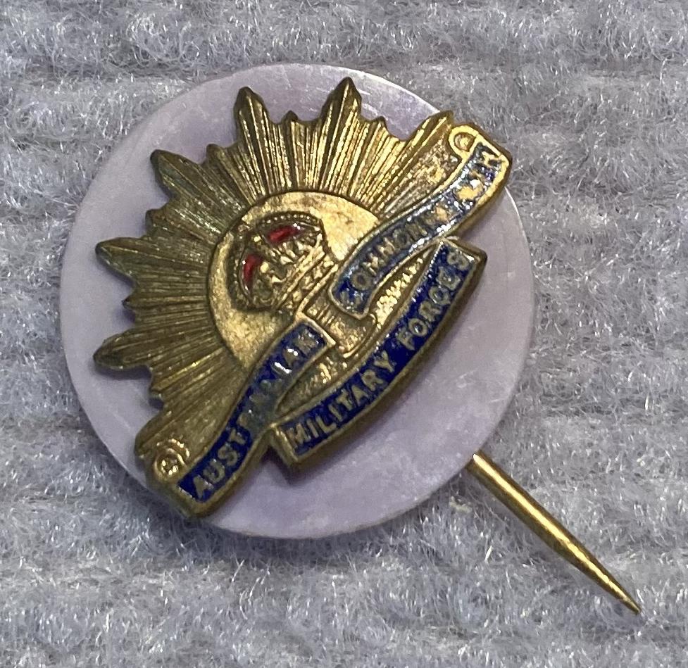 Angled view of miniature Rising Sun badge stick pin on lilac backing