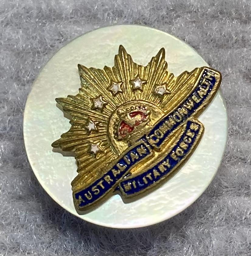 Angled view of miniature Rising Sun badge brooch with mother of pearl backing