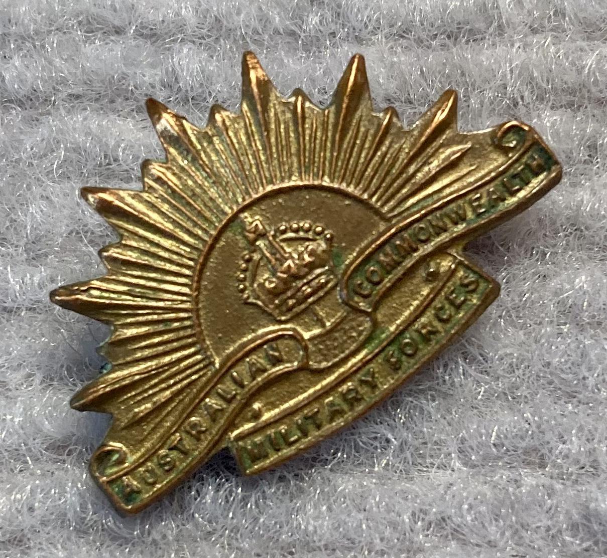 Angled view of miniature Rising Sun badge gold tone metal brooch - 1