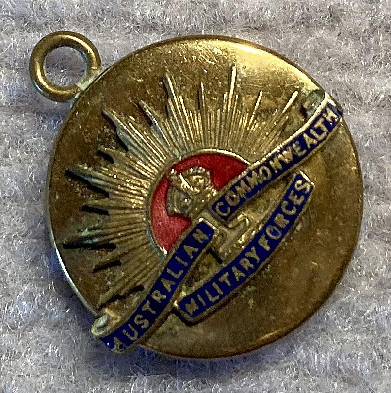 Angled view of gold tone metal and enamel Rising Sun badge sweetheart pendant locket 
