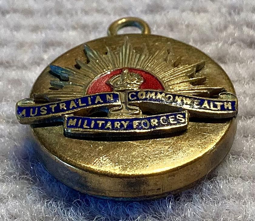 Oblique view of gold tone metal and enamel Rising Sun badge sweetheart pendant locket 