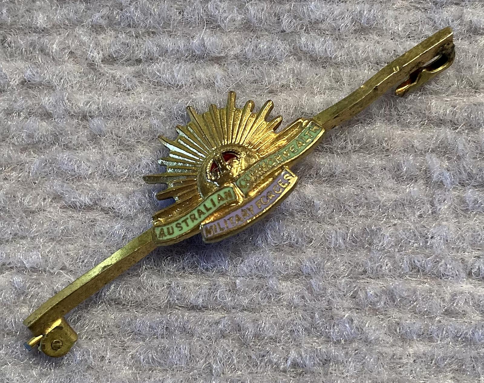 Angled view of gold tone metal and enamel Rising Sun badge sweetheart lapel brooch/tie pin