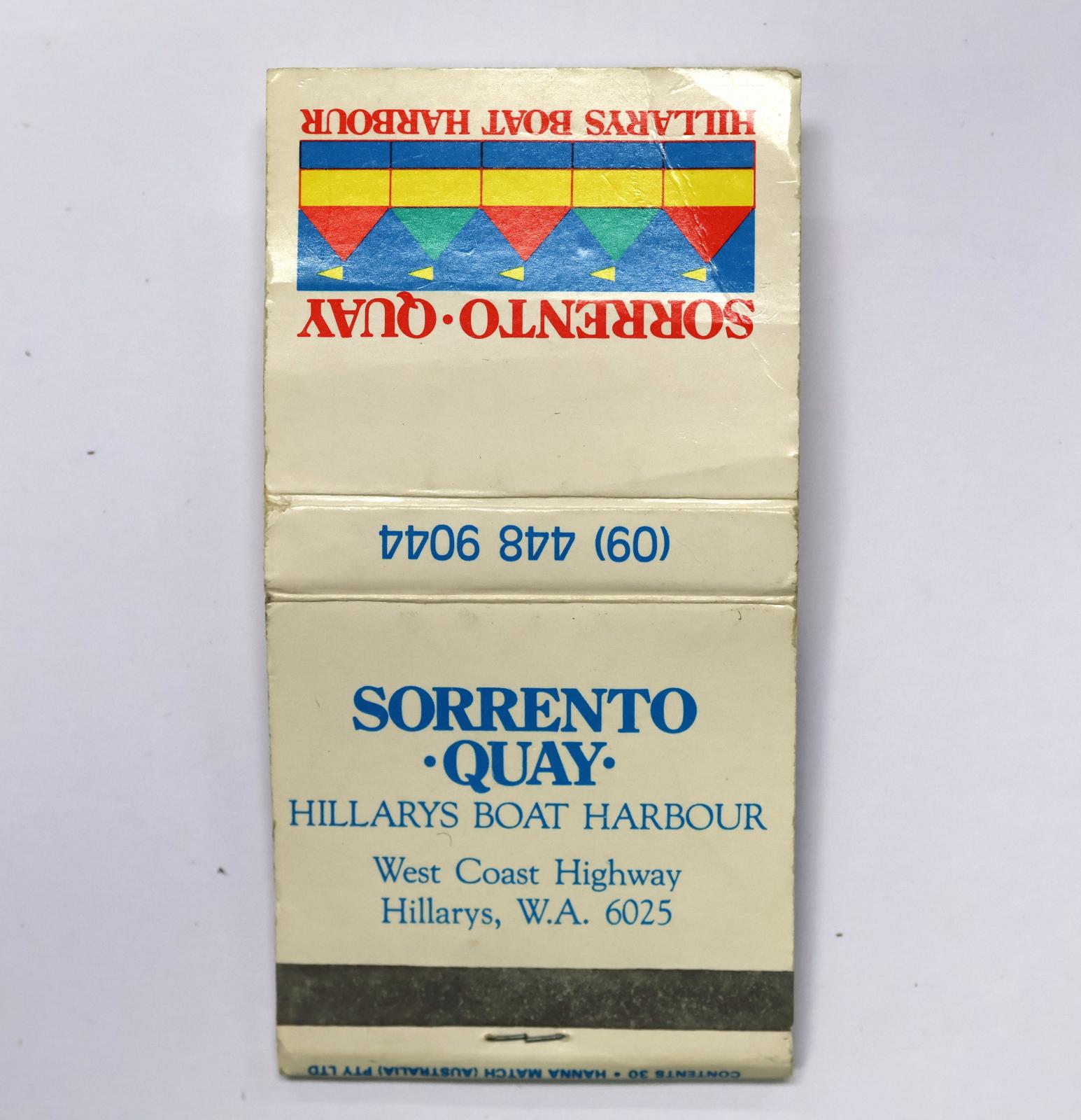 Square shaped matchbook, white background with red text on the front, blue text on the reverse and on the inside. The back of the matchbook has a brown igniting panel. 