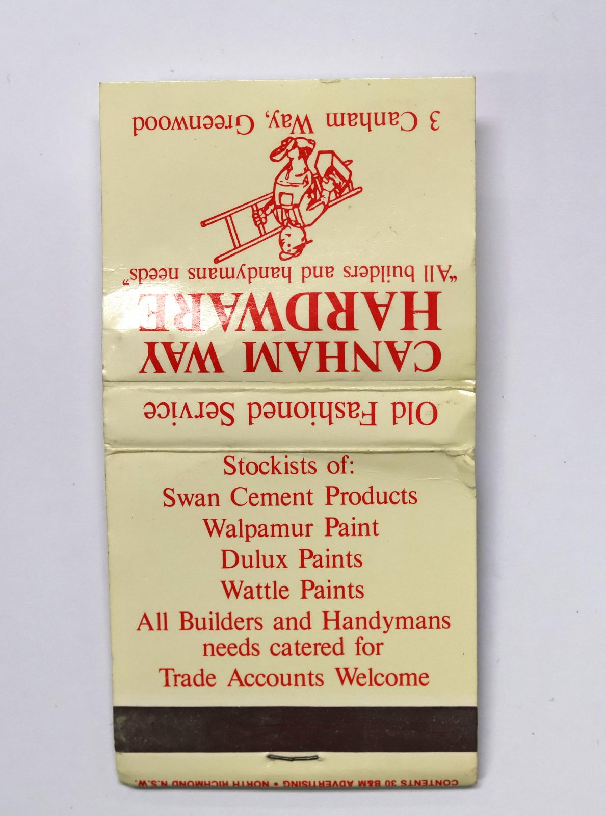 Square shaped matchbook with white coloured background and red text and image.  The back of the matchbook has a brown igniting panel. 
