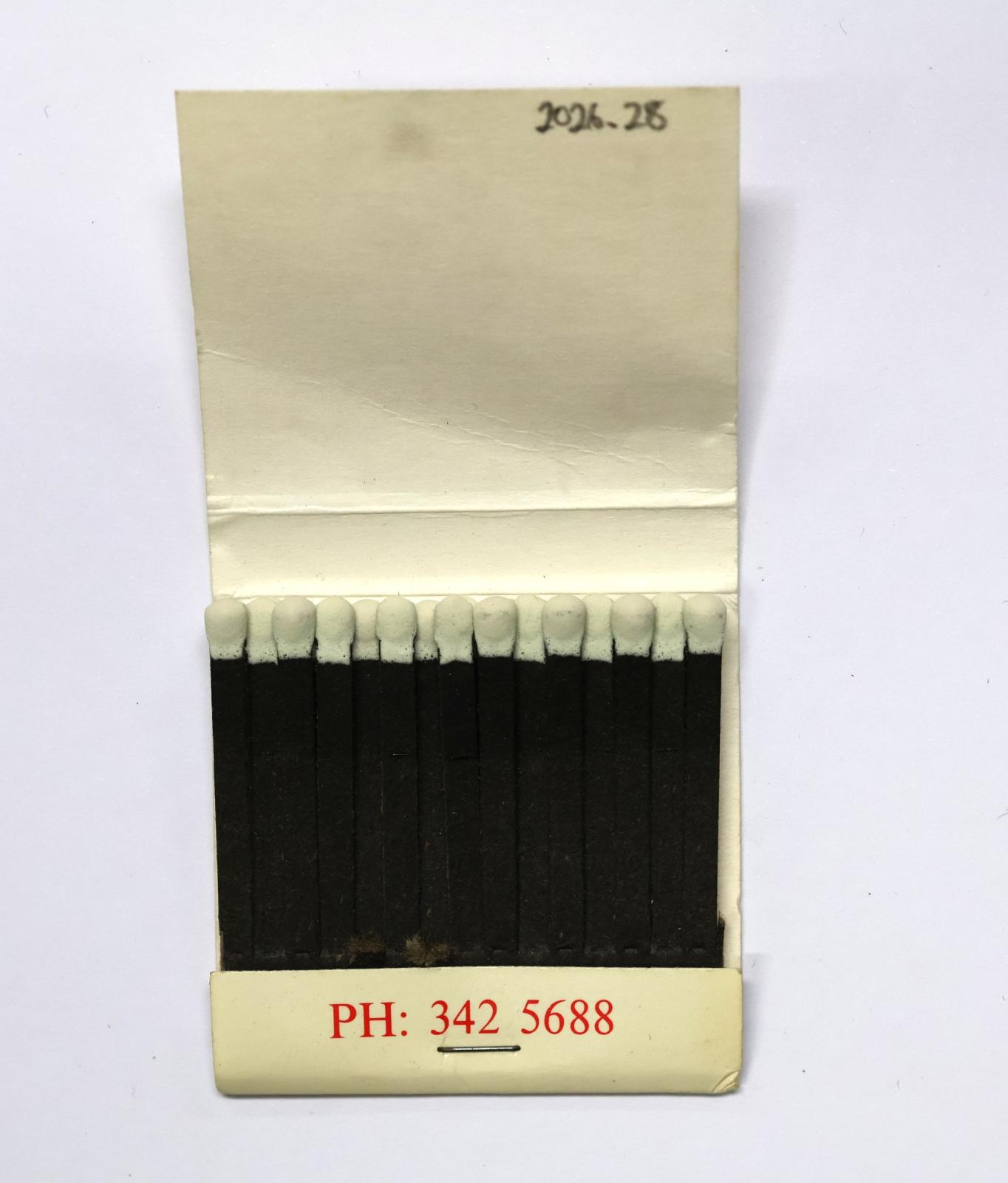 The inside has 28 black matchsticks with white match heads, two matches are missing.  