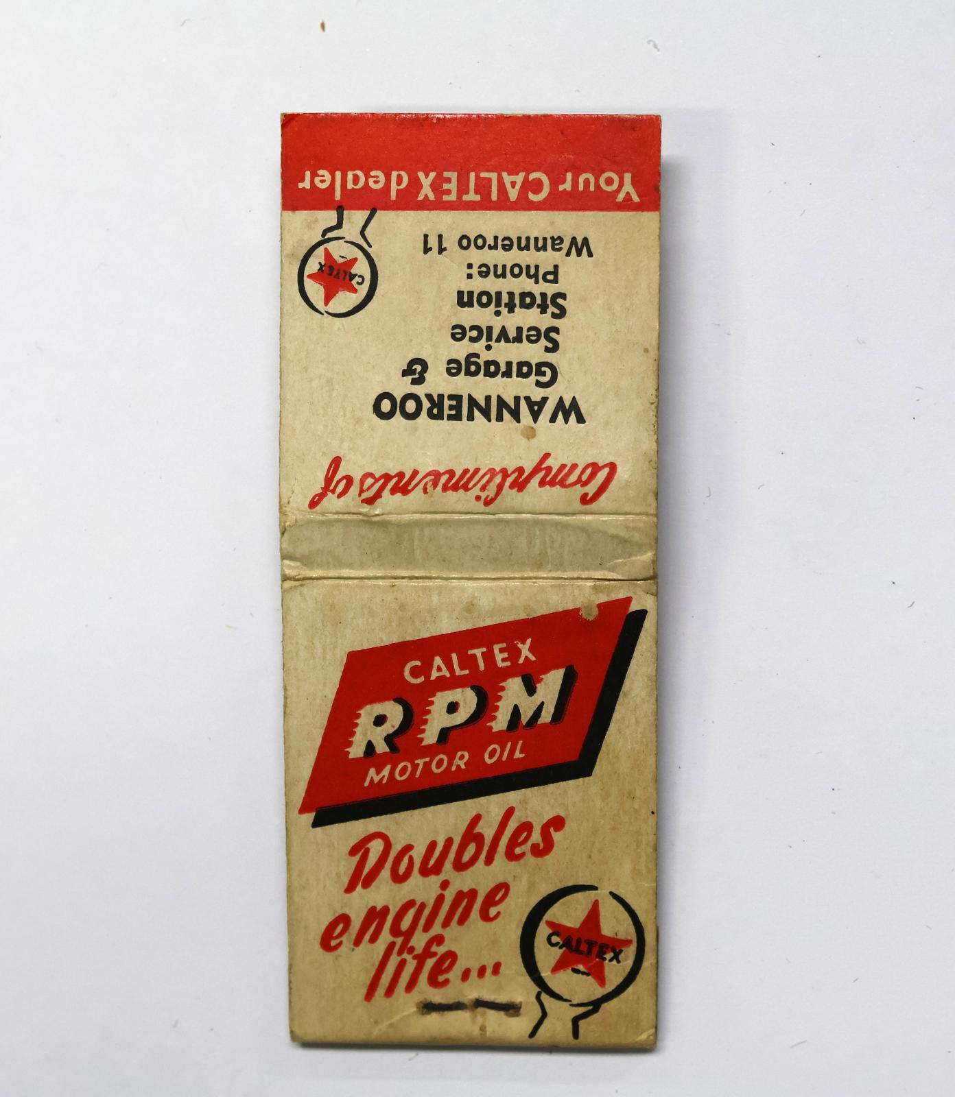 Rectangular shaped matchbook with white background and red, black and white text. The front of the matchbook has a brown igniting panel. 