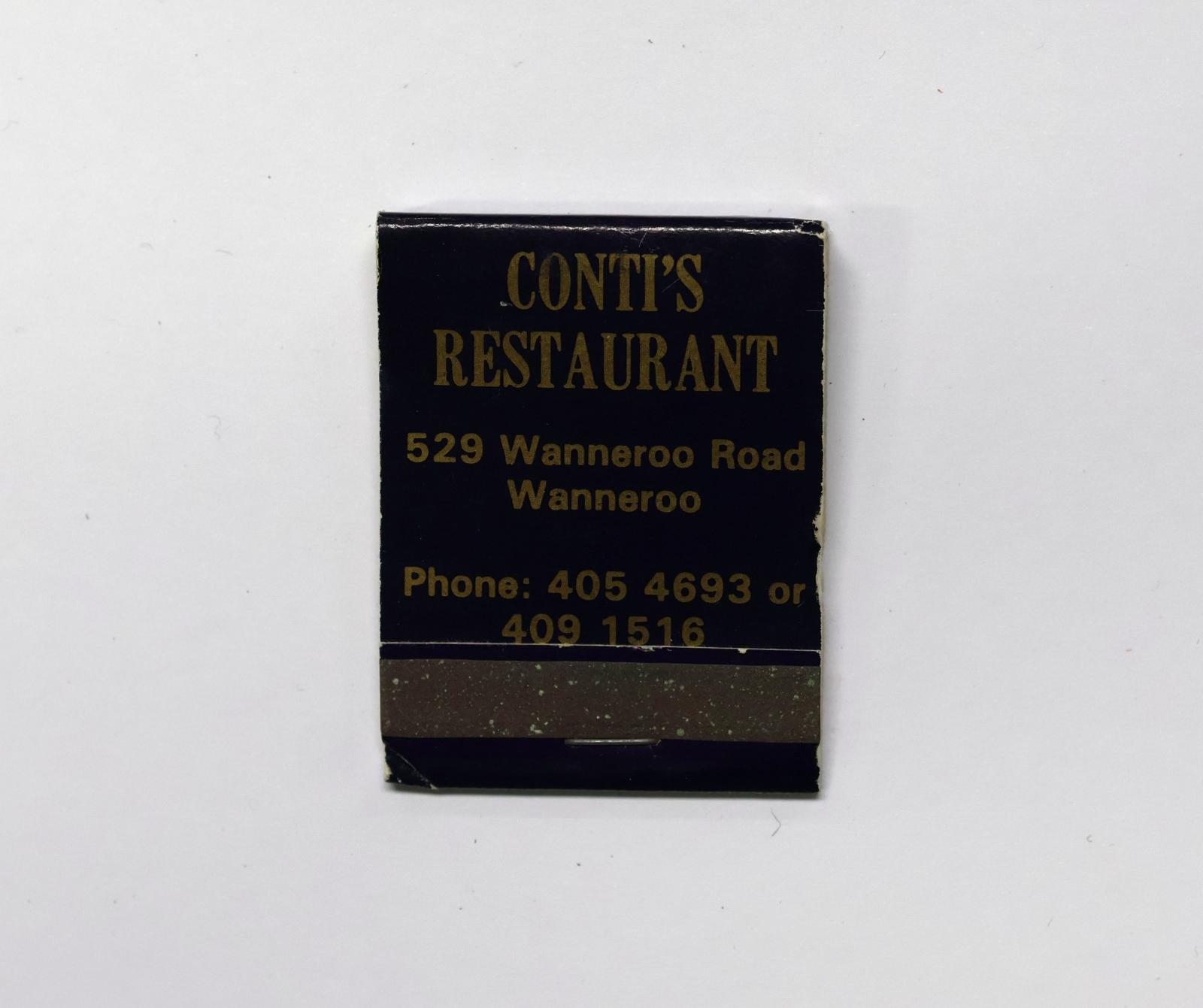 Rectangular shaped matchbook with dark blue background and gold text.  The front of the matchbook has a brown igniting panel. 