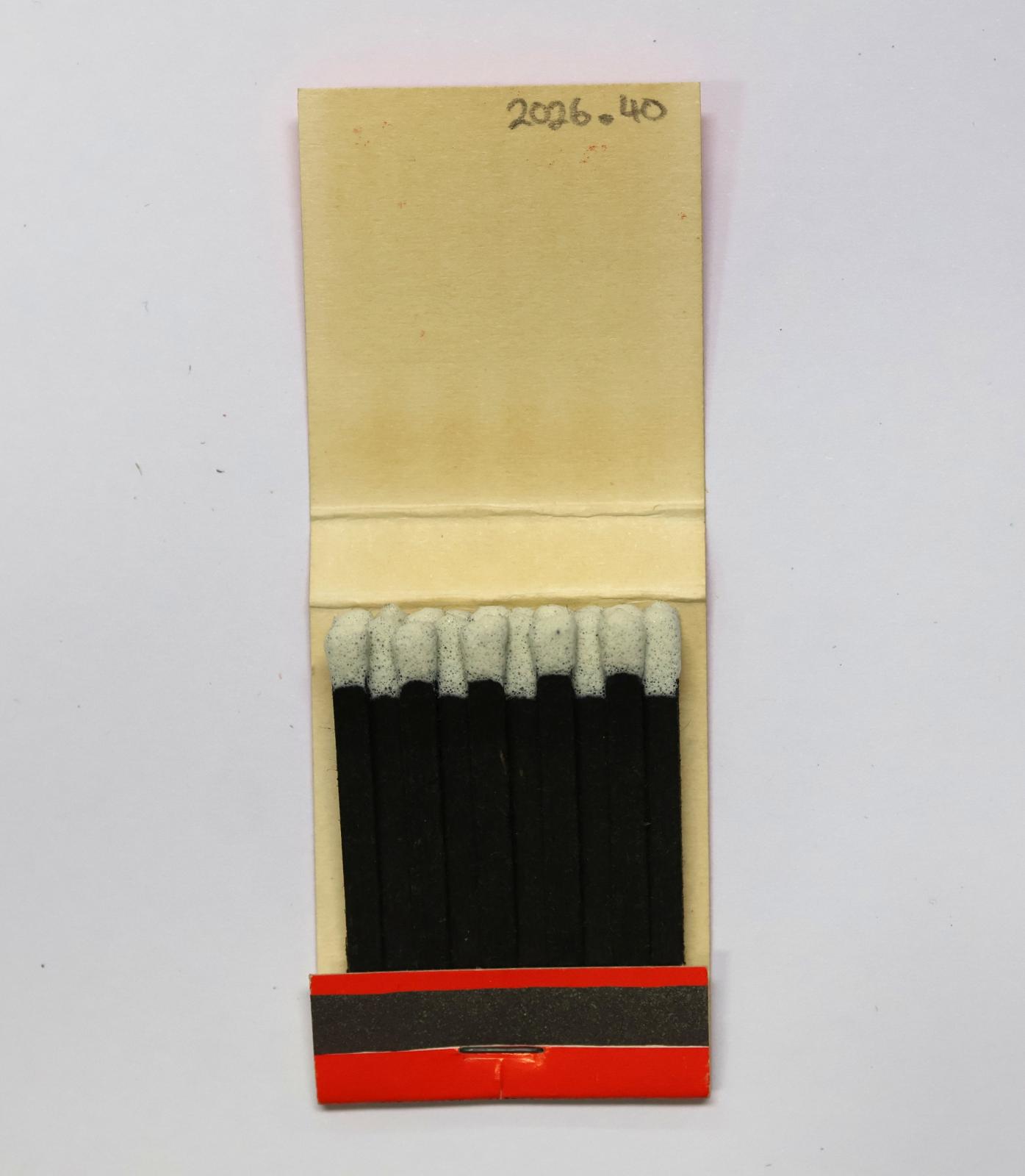 The inside has 20 black matchsticks with white match heads.