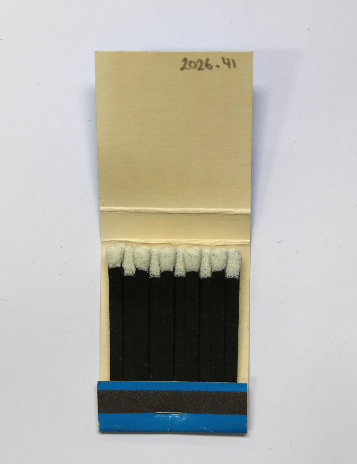 The inside has 20 black matchsticks with white match heads.