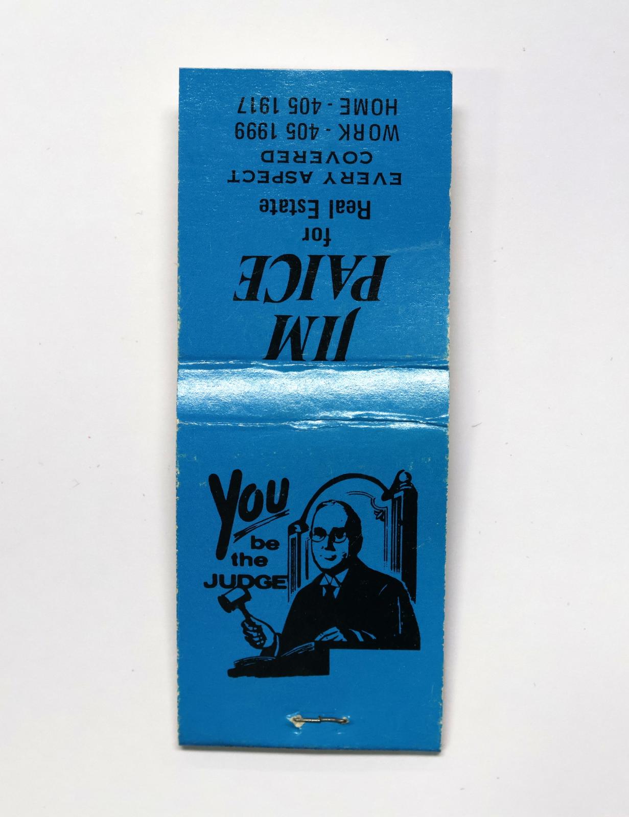 Rectangular shaped matchbook with blue background and black text.  The front of the matchbook has a grey igniting panel. The back of the matchbook has an image of a judge with a gavel.
