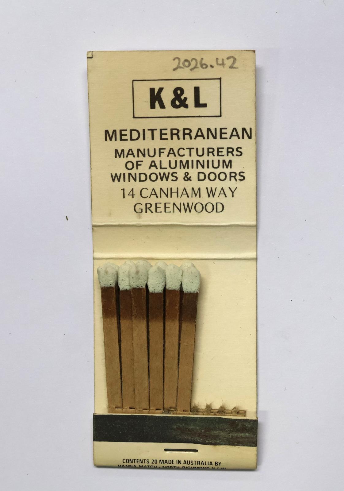 Rectangular shaped matchbook with white background and black text. The front of the matchbook has a grey igniting panel. The inside has 11 brown matchsticks with white match heads.
