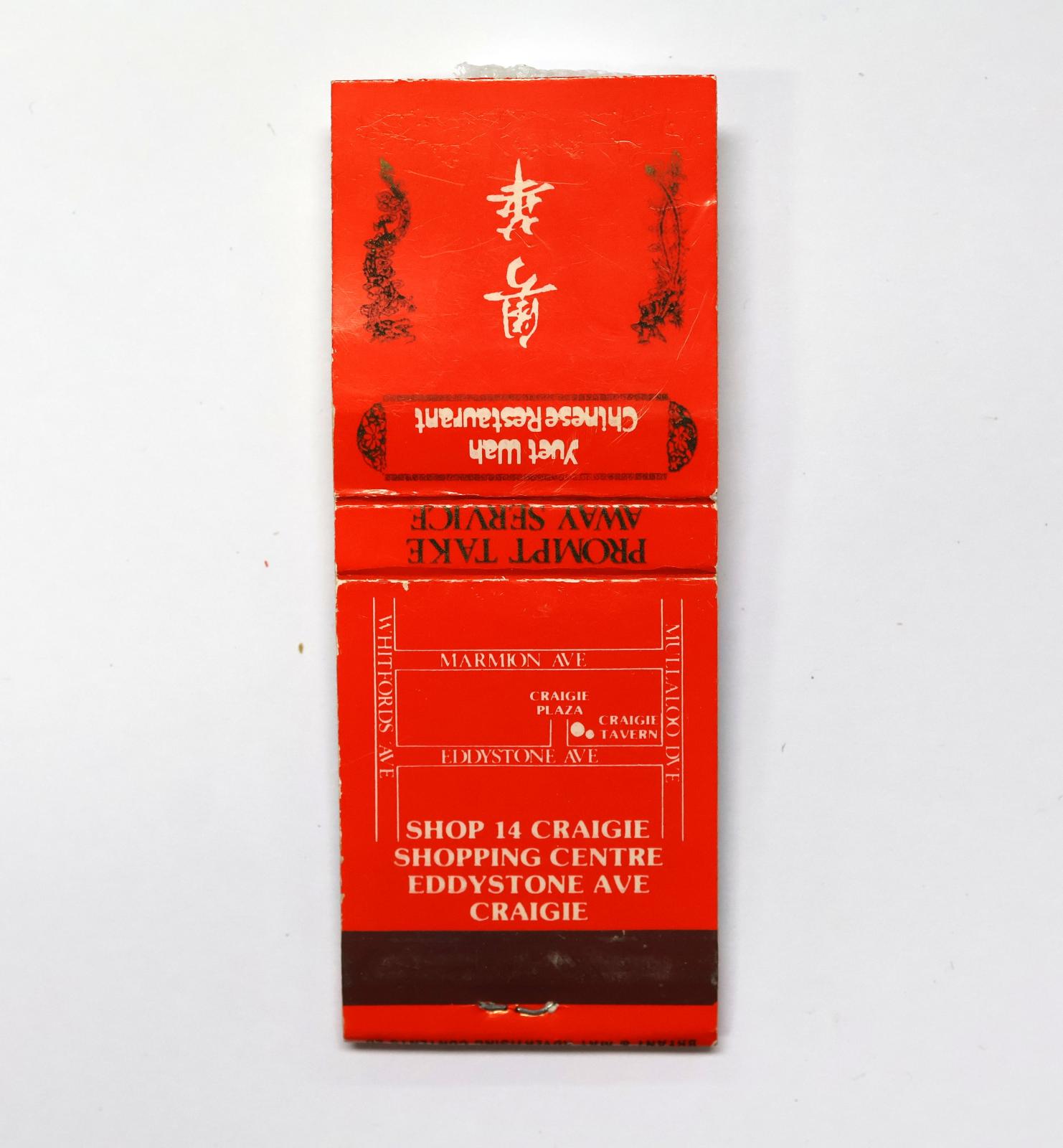 Rectangular shaped matchbook with red background and white text. The back of the matchbook has a brown igniting panel. The front and the back of the matchbook have white text, there is map of the location on the back. 
