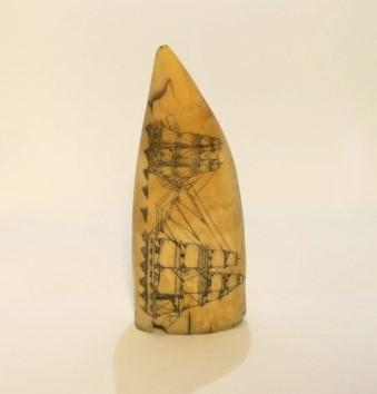 Scrimshaw depicting two whaling ships on one side and male and female figures on other side.