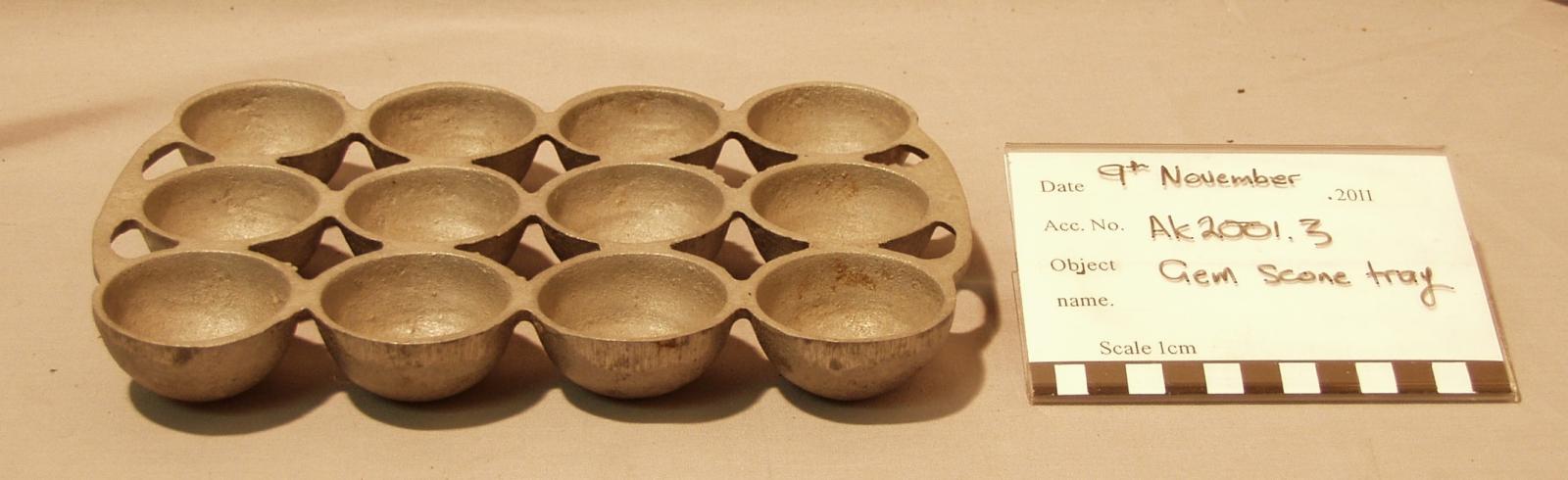 Rectangle metal tray made up of three rows of four hemispherical cups