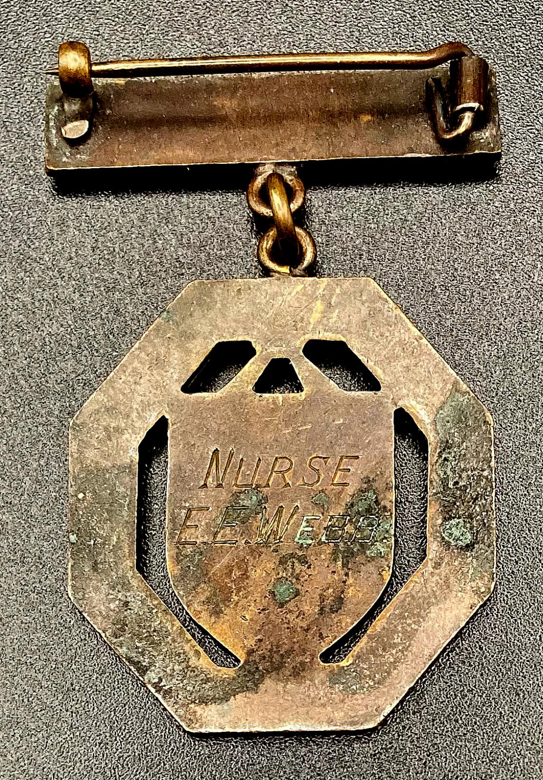Reverse of Birmingham United Hospital Queen Elizabeth Hospital badge presented to Nurse E.E. Webb