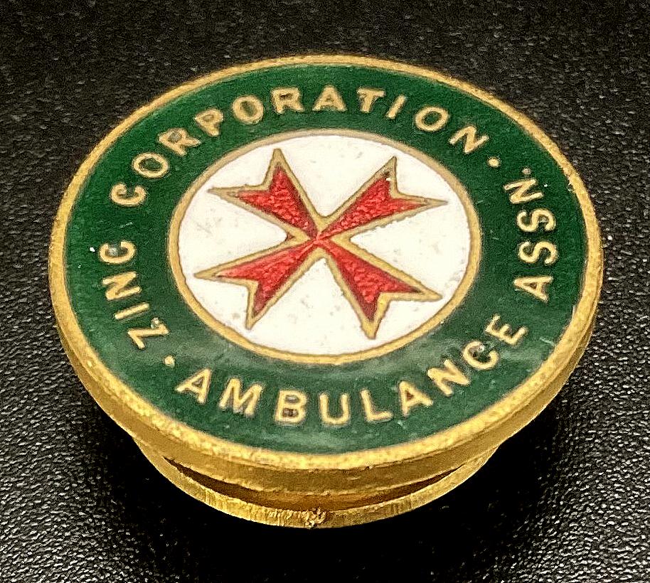 Angled view of Zinc Corporation Ambulance Association enamel badge
