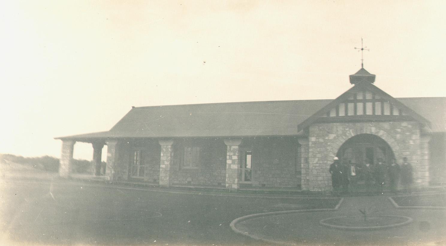 A group of men from the ministerial tour, standing in front of the main building on Mount Narryer Station.