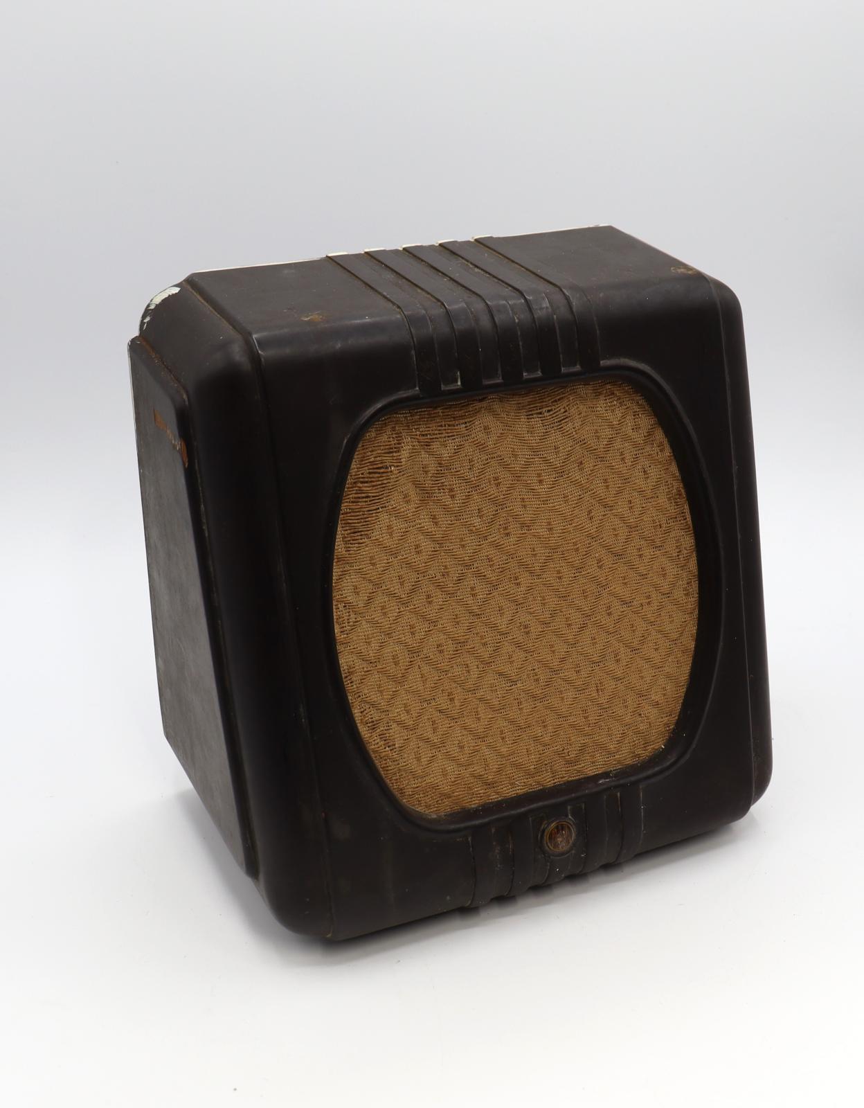 Brown square bakerite speaker with a hatched design cloth cover over the speaker valve on the front of the speaker