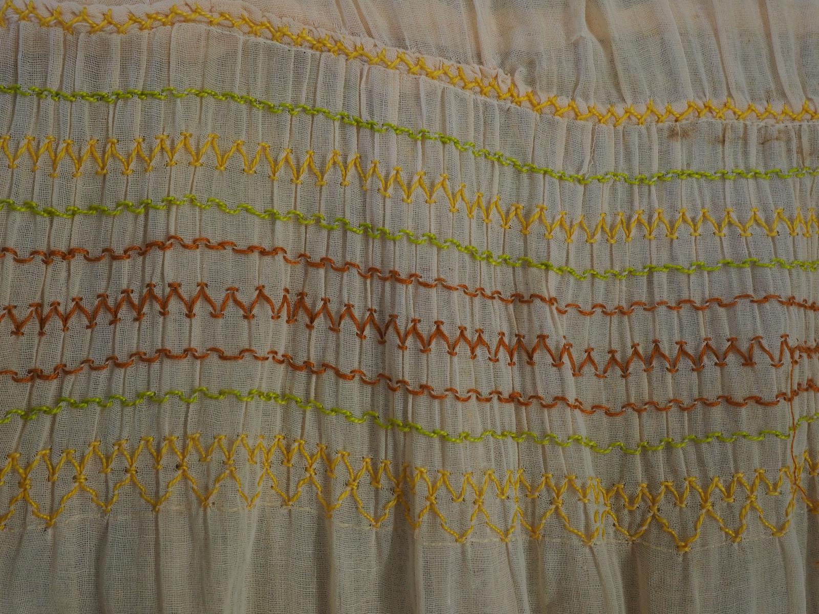 Smocked and embroidered dress detail