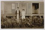 man and woman standing next to tree in front of building