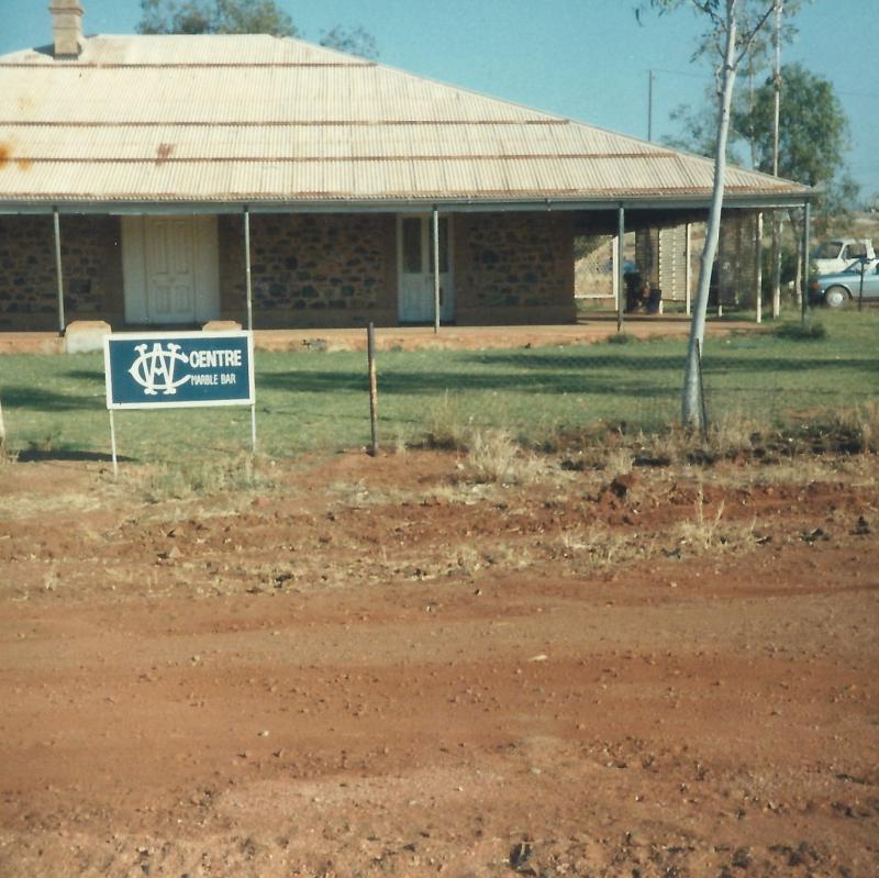 photograph of building and dirt road