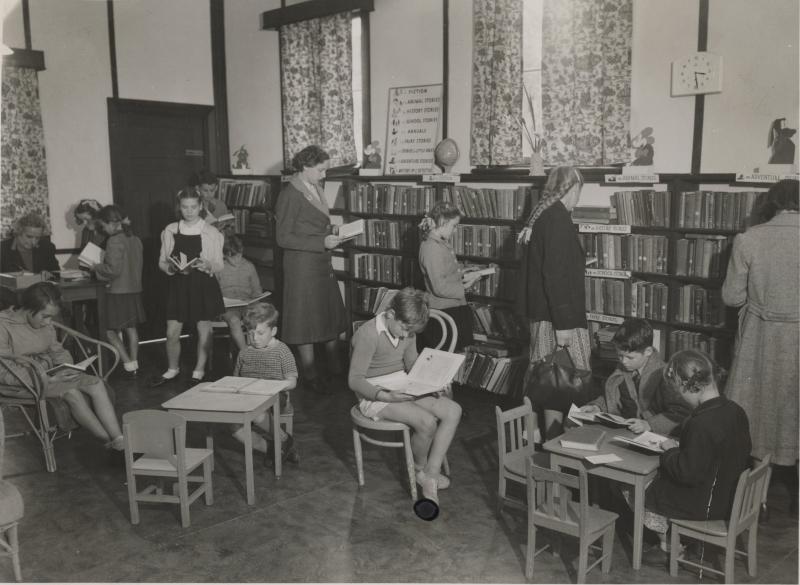 Children reading books in a public library.