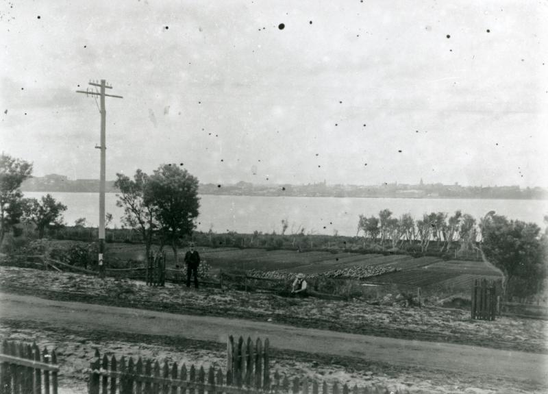 Black and white photo of market gardens by a river