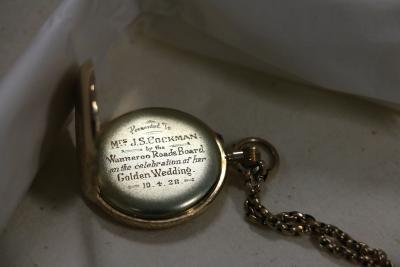 Image of a Gold Fob Watch lying open, the engraved inscription is visible.