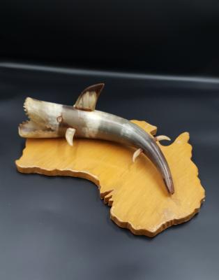 wooden map of australia with shark made out of bone on top
