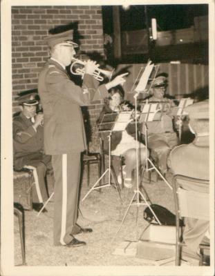 Man playing a trumpet and conducting a Band