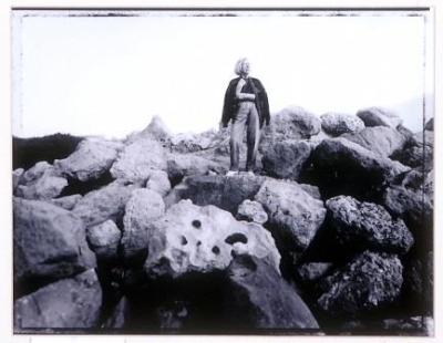 Black and white photograph print of Joan Campbell standing on rocks