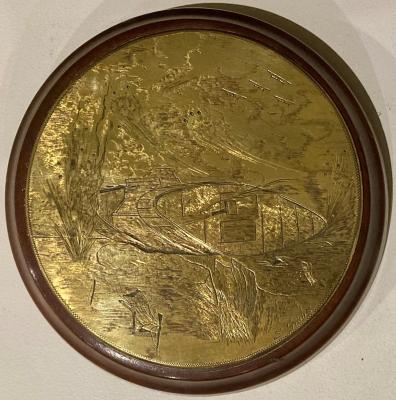 Bronze plaque depicting WWI battle scene with a tank