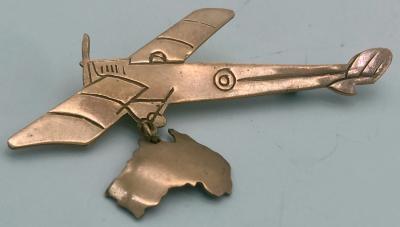 Metal brooch featuring a plane with an attached map of Australia