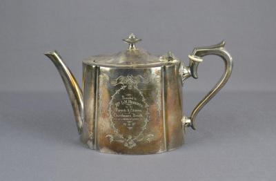 Metal silver plated tea pot with engraved text on the side