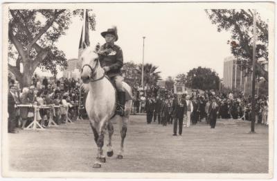 Black and white photo of Henry (Harry) RISEBOROUGH riding a police grey leading the 1975 Perth Anzac Day Parade.