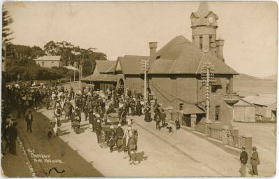 Black and White Photographic Postcard of The Darktown Fire Brigade walking past the Albany Post Office