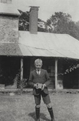 Lad With Camera At Rear Of House