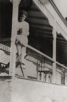 Young Woman With Camera On A Verandah