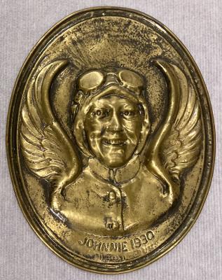 Pressed brass wall plaque featuring the relief portrait of aviatrix Amy Johnson