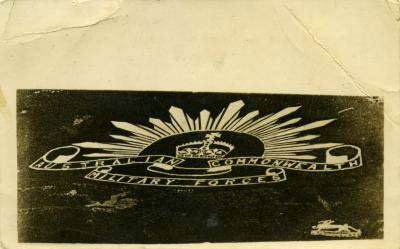 RPPC of Australian Rising Sun badge carved into chalk hills in Wiltshire