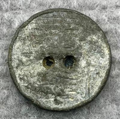 Lead button from clothing worn by munitions worker