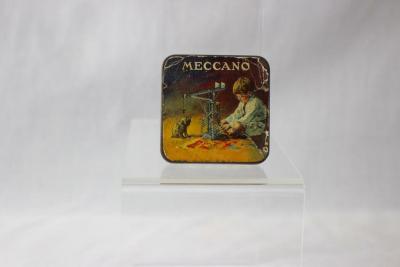 An original Meccano tin from circa 1930, containing an assortment of miniature screws, washers, and fasteners used in early Meccano construction sets.