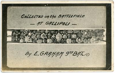 Postcard showing a belt with numerous military badges and buttons attached.