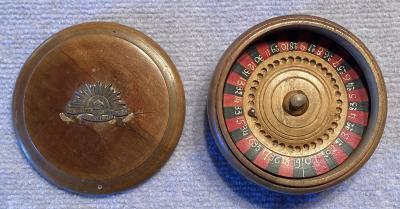 Trench art timber roulette wheel with Rising Sun badge