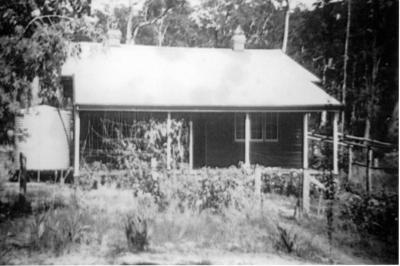 Timber home, with water tank, plus trellis at side of home.