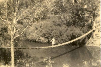 Merva Longbottom standing on Carey's suspension bridge over the Blackwood River early 1940's